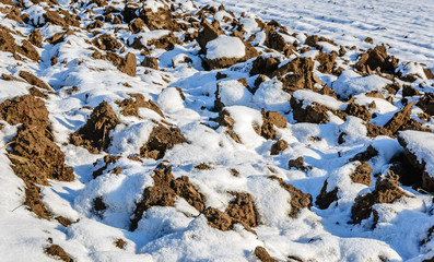Plowed field with a thin layer of snow