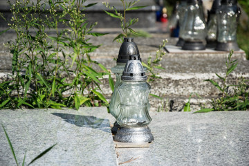 Votive candles lantern on the grave in Slovak cemetery. All Saints' Day. Solemnity of All Saints. All Hallows eve. 1st November. Feast of All Saints. Hallowmas. All Souls' Day