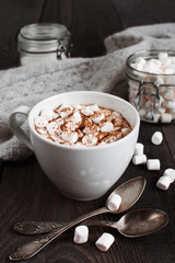 The cap of beverage with marshmallow on the dark wooden table