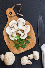 fresh champignon mushroom over wooden cutting board