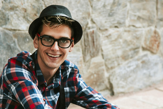 close-up portrait smiling young man with plaid shirt apron and hat, workers