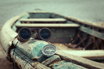 Travel concept, compass, sand and rope on wooden background