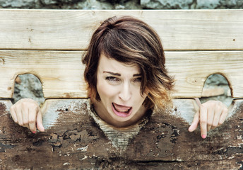 Young caucasian woman in medieval pillory, punishment device