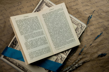 still life. old books, silk blue ribbon and lavender on a background  paper. close-up. top view