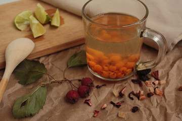 sea buckthorn tea in a transparent mug and a rose hip lime. useful warming winter drink.

