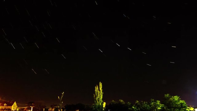 Star Trails Galaxy Spins over the Small Town. Timelapse.

