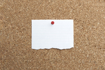 Lined paper with push-pin on corkboard