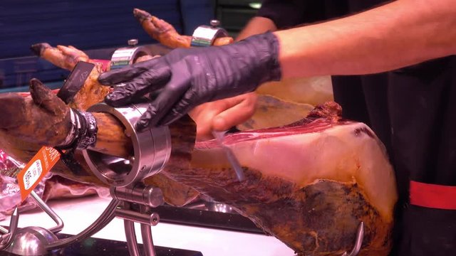 Cutting thin slices of Iberic ham for Spanish tapas