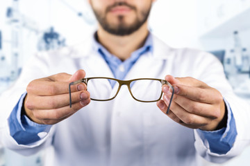 eyesight care concept - optician giving new optical glasses