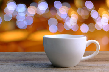 White Coffee cup on wooden table in coffee shop blur background.