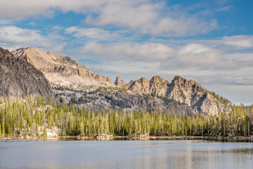 Dramatic lighting on jagged mountain peaks with lake