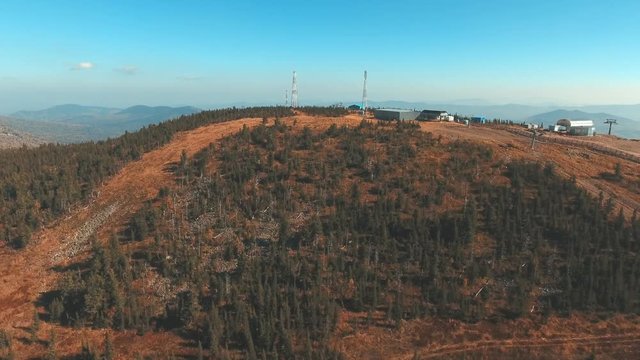 Conifer in mountains. Flying with drone over woodland in a beautiful sunny day of autumn. Mountain tress from a bird-eye view. Landscape with forest and mountains in Siberia (Shoria)