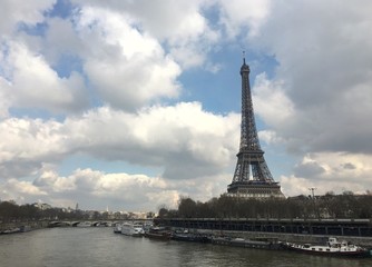 Fototapeta na wymiar Paris, France - February 25th : view of the Eiffel Tower along the Seine river and bridge crossing the river during winter 