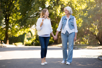 Obraz premium Two delighted pretty women walking in the park.