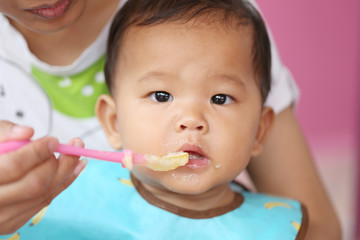 Asian baby boy to eating food in concept of health foods and nut