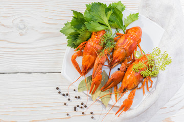 Вареные раки и пряности на тарелке на деревянном столе