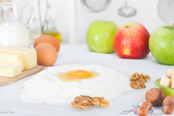 Ingredients for baking apple pie: flour, eggs, butter, sugar and walnuts