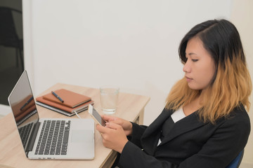 young business woman working on his laptop and using smart phone