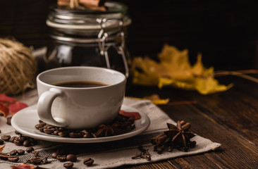 Cup of coffee with ingredients, spices and some kitchenware.