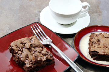Chocolate chip brownie in a plate with milk and chocolate chips