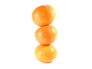 Close-up of vertically piled up three ripe oranges isolated on white background 