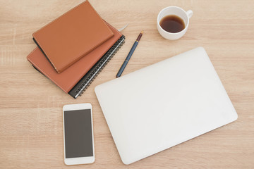 Laptop screens on working desk with a pen, Notebook, text book,