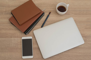 Laptop screens on working desk with a pen, Notebook, text book,