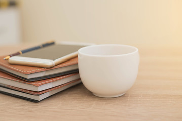 notebook,phone,pen and cup of coffee on work desk