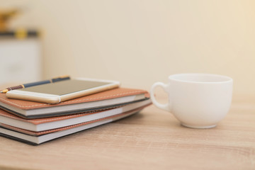 Obraz na płótnie Canvas notebook,phone,pen and cup of coffee on work desk