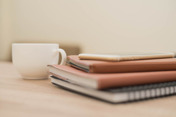 notebook,phone,pen and cup of coffee on work desk