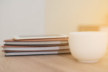 notebook,phone,pen and cup of coffee on work desk