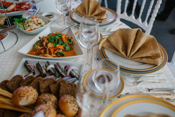 Rich dinner table served with fish and vegetables and plates wit