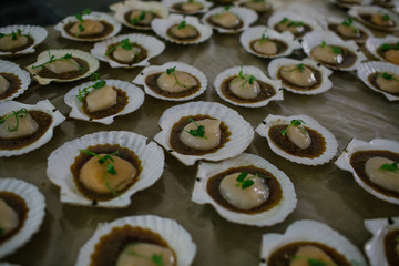 Porcelain white shells with appetizers lie on the table