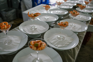 Tasty shrimps served with green olives in cocktail glasses