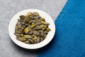 Pumpkin seeds in white bowl Copy space