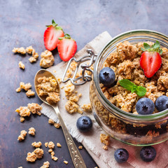 Homemade muesli granola in a jar on rusty black table