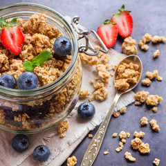 Homemade muesli granola in a jar on rusty black table