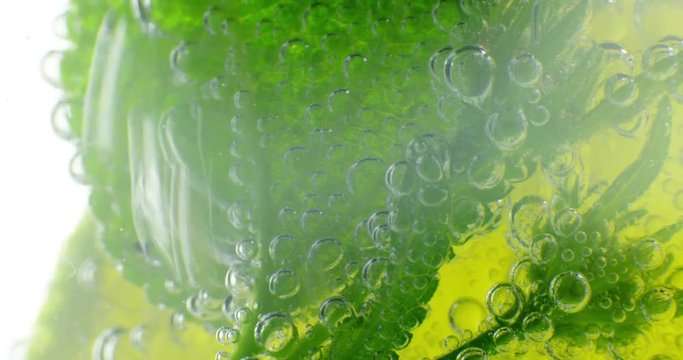 Sparkling bubbles water with a slice of lime. 4K macro footage, shot on RED