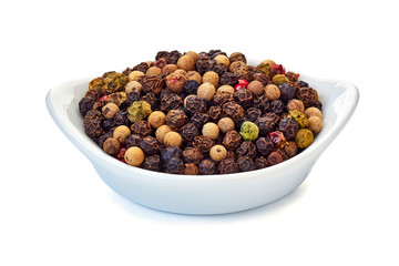 Heap of various peppers grains in bowl on white