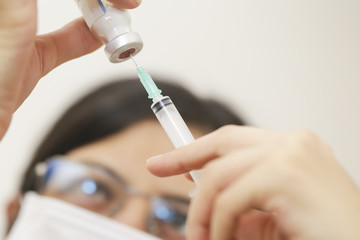 nurse hands holding syringe and ampoule