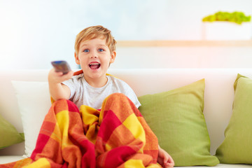 excited boy, kid watching tv at home © Olesia Bilkei