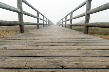 Wooden walkway, which is lost in the fog. Town of Tarifa, Spain.
