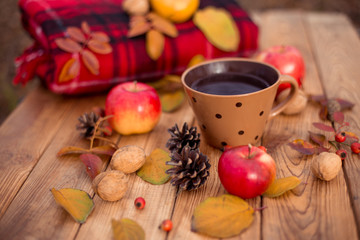 Autumn composition on a wooden background. Still life, food and drink, apples, pumpkin, nuts, cone, tea.
