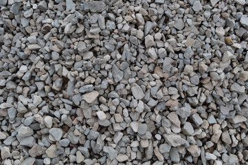 Abstract grey and beige gravel stone background, crushed gray stones and granite pieces texture, large detailed horizontal textured rough construction rock material mix pattern