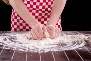 Cook preparing dough for baking in the kitchen