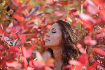 girl in the red leaves in autumn
