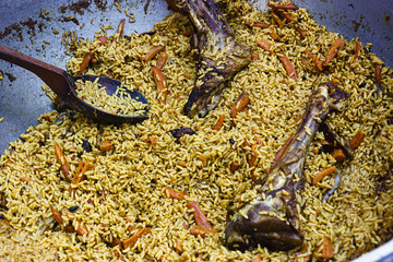 large cauldron with pieces of lamb pilaf and carrots