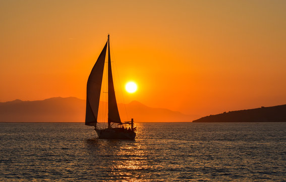 Fototapeta Sailing boat on the sea at sunset.