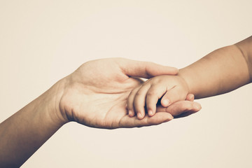 Mother holding a baby's hand in old vintage tone