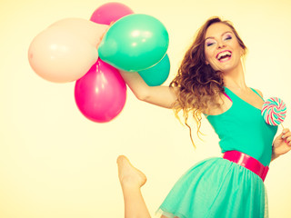 Woman with colorful balloons and lollipop